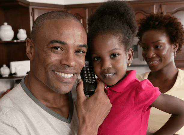 Father and daughter using a landline telephone